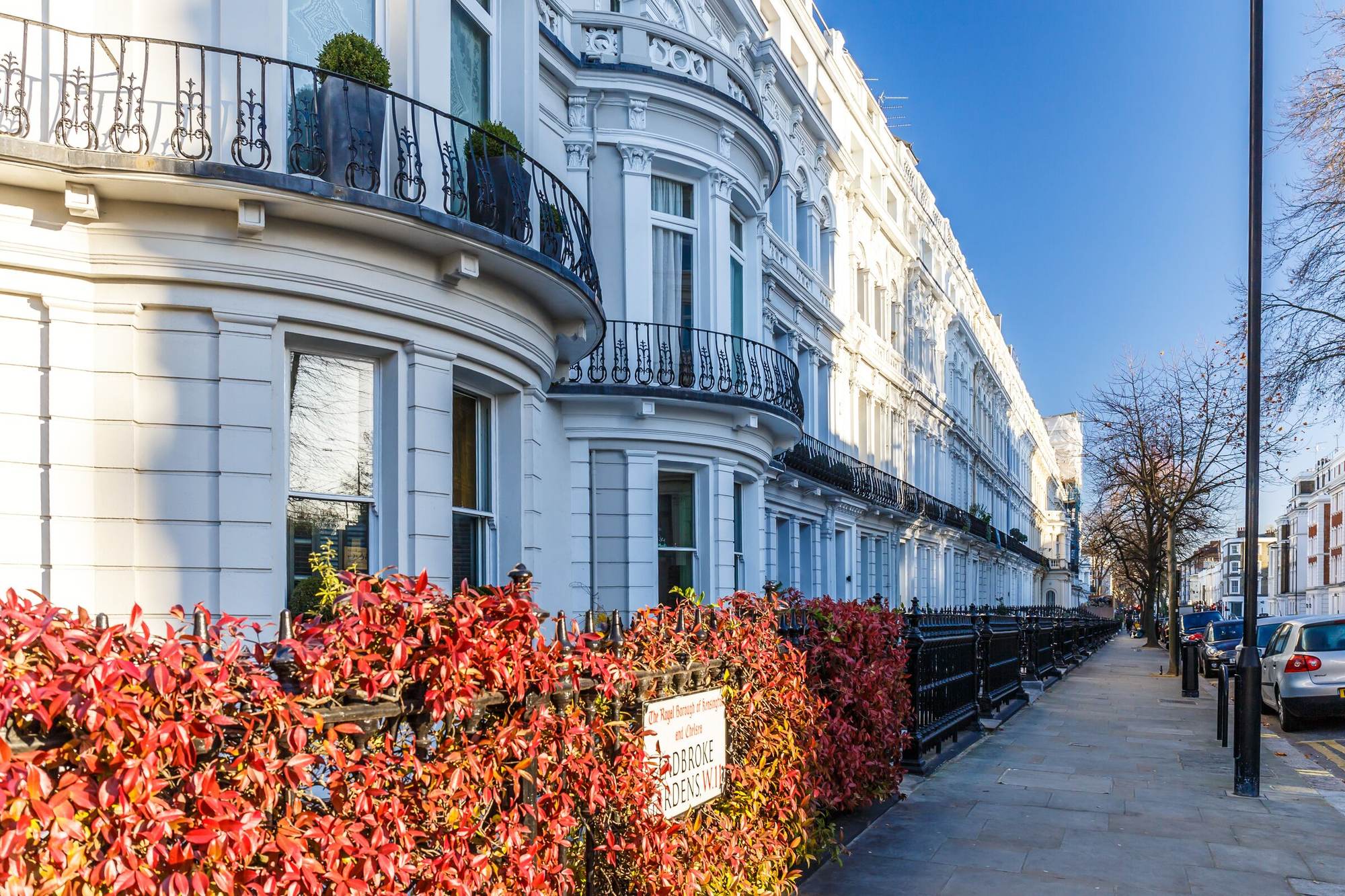 A white stucco terrace in prime London with autumn foliage along the railings